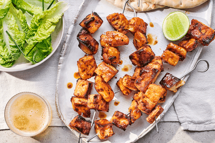 Halloumi skewers with chipotle and lime on a serving plate with lettuce on the side