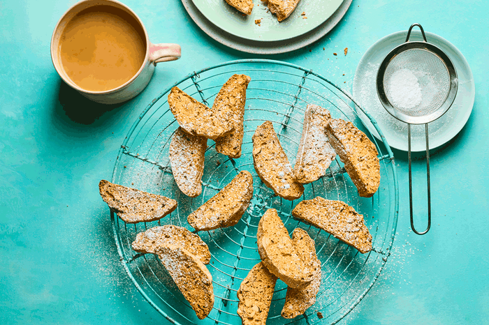 Pieces of biscotti on a wire rack on a blue background