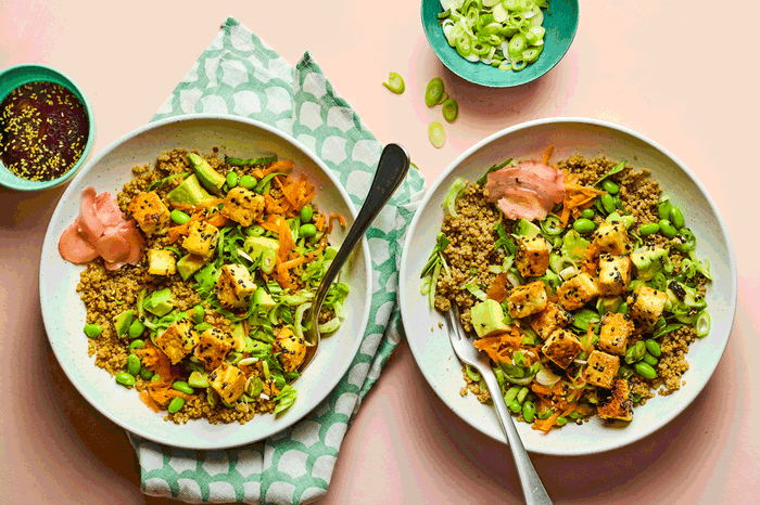 Bowls of cooked quinoa with edamame, pak choi and tofu