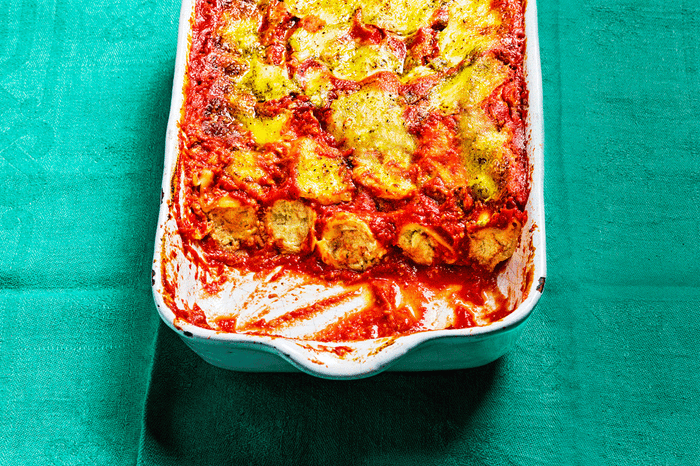 Shiso leaf pesto and ricotta cannelloni in a baking dish on a teal background