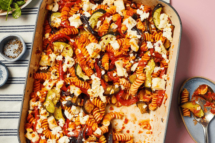 Vegetable pasta bake topped with feta in a baking dish