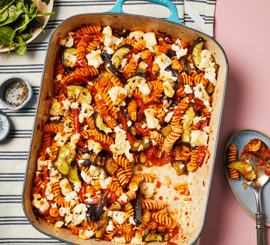 Vegetable pasta bake topped with feta in a baking dish