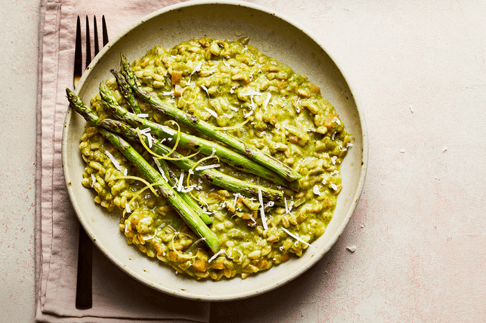 Watercress risotto in a bowl with asparagus on top